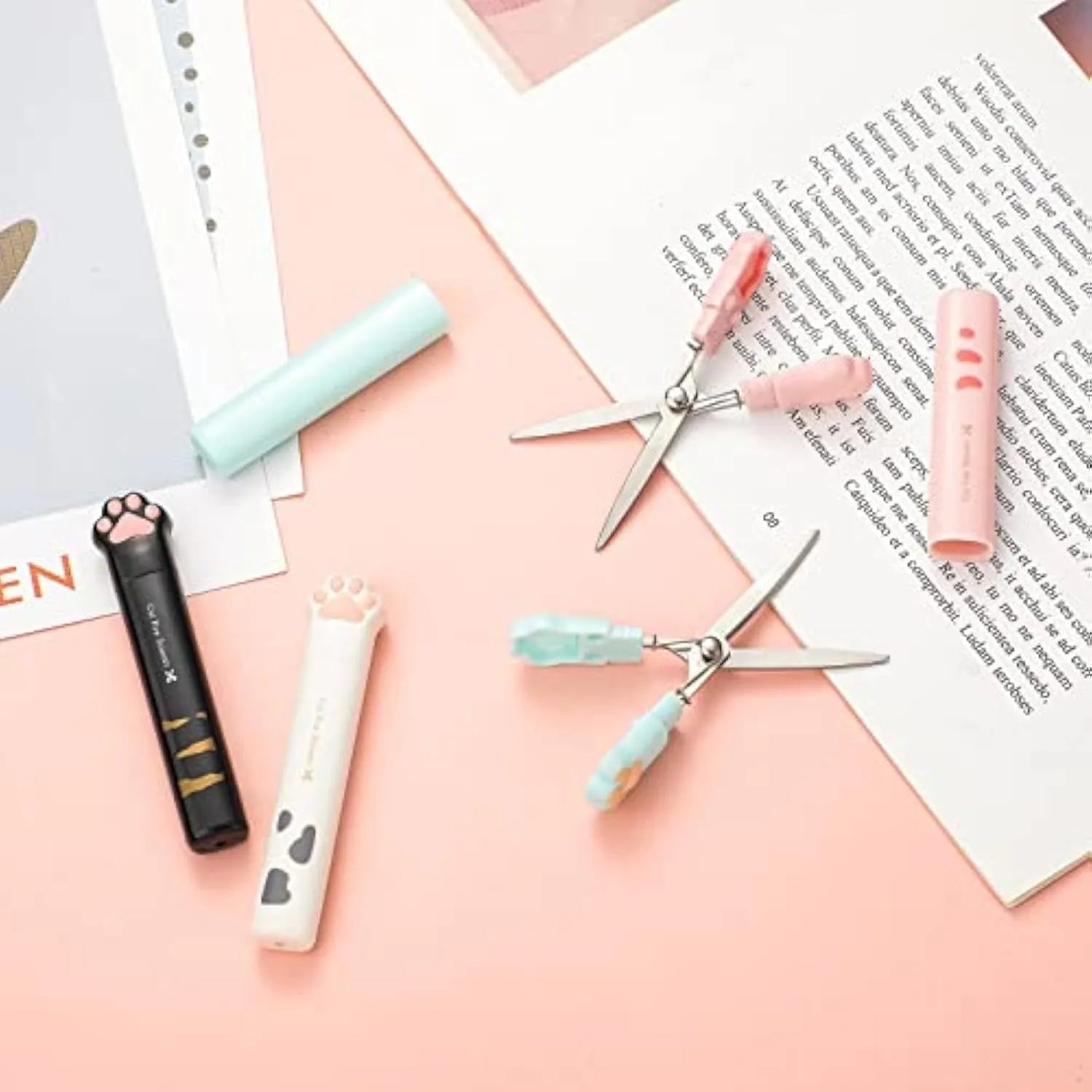 Small folding scissors with cat paw design on handles in choice of four colours, shown with blades safely closed.
