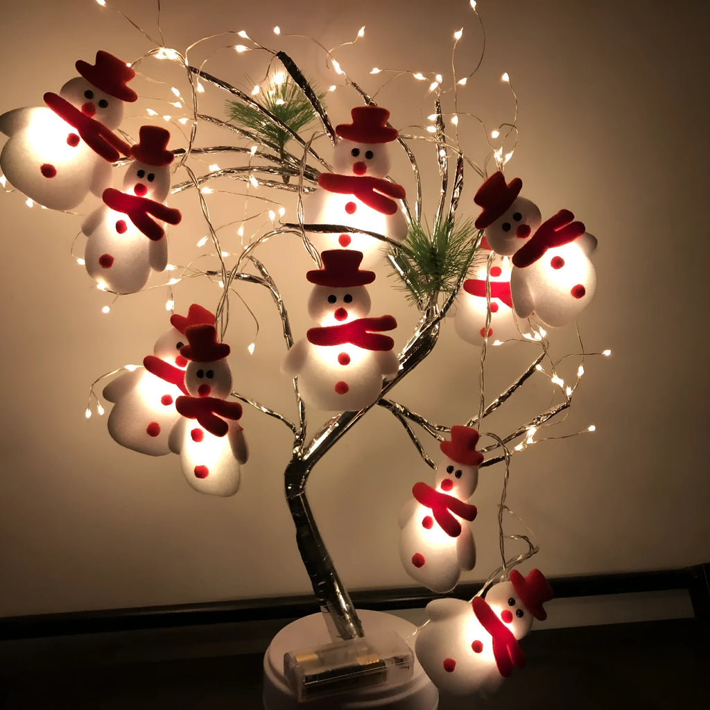 Christmas LED string lights with warm white glow showing snowman and elk deer themed lamps on a dark background