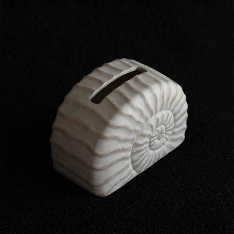 Modern conch ramble patterned resin decorative tissue box holder on a table.