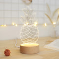 Cartoon pineapple design night light with wood and acrylic construction on bedside table