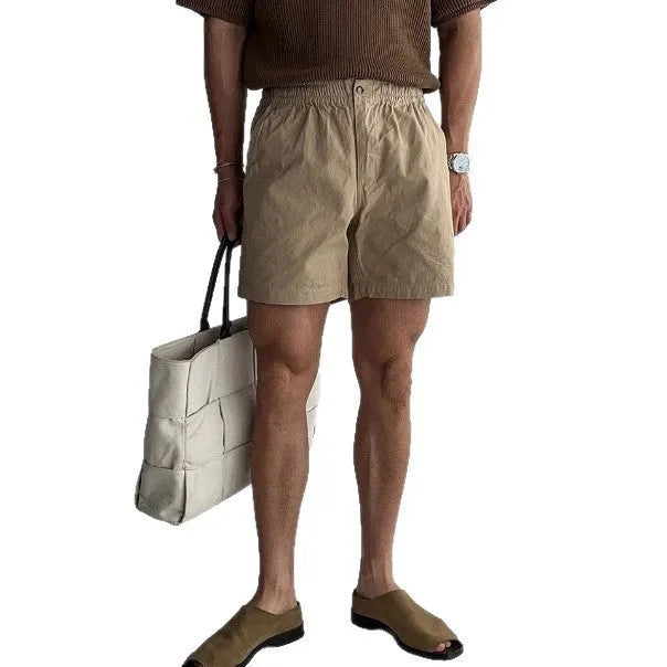 Men's loose-fit cotton sports shorts in black, shown on a hanger against a white background.