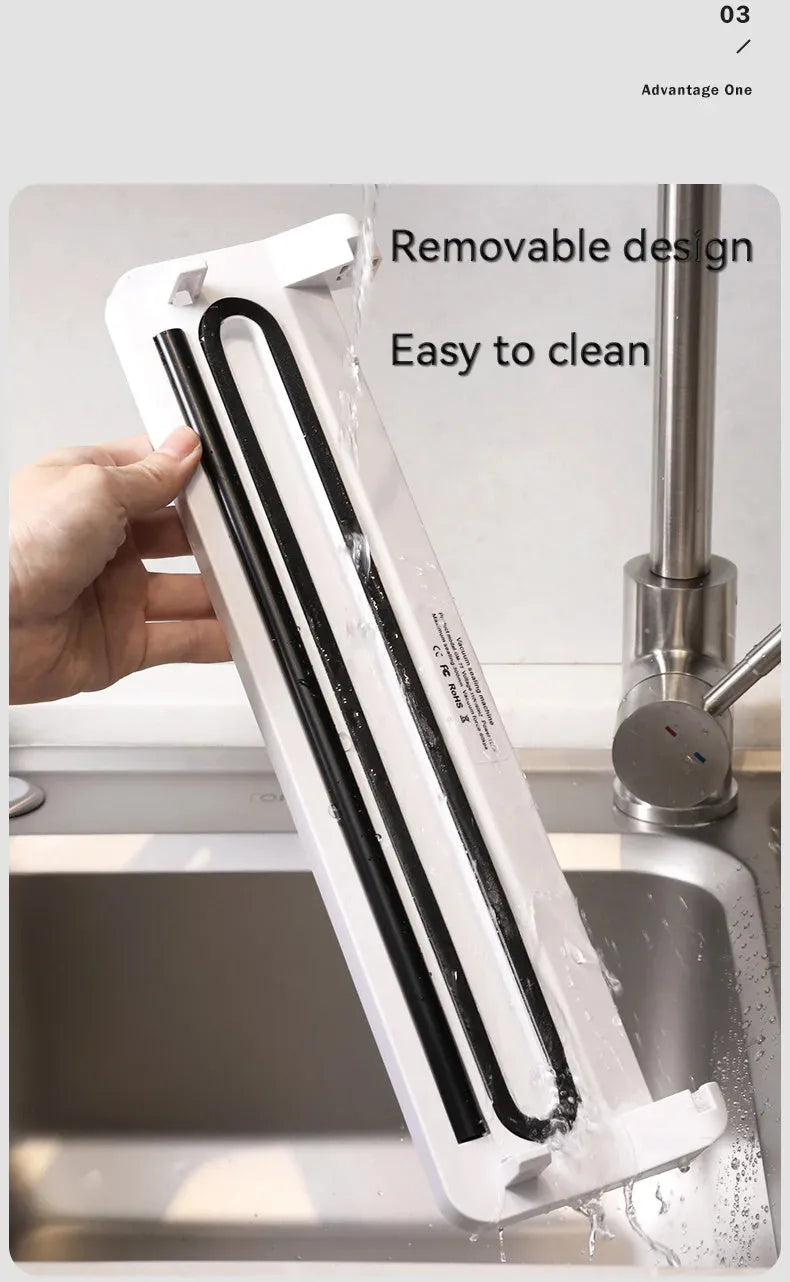 White automatic vacuum sealer machine for household food preservation on a kitchen counter.