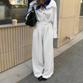 White striped wide-leg trousers with a zip fastening, laid flat.