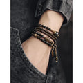 Unisex black beaded geometry multi-layered bracelet with natural style on plain background