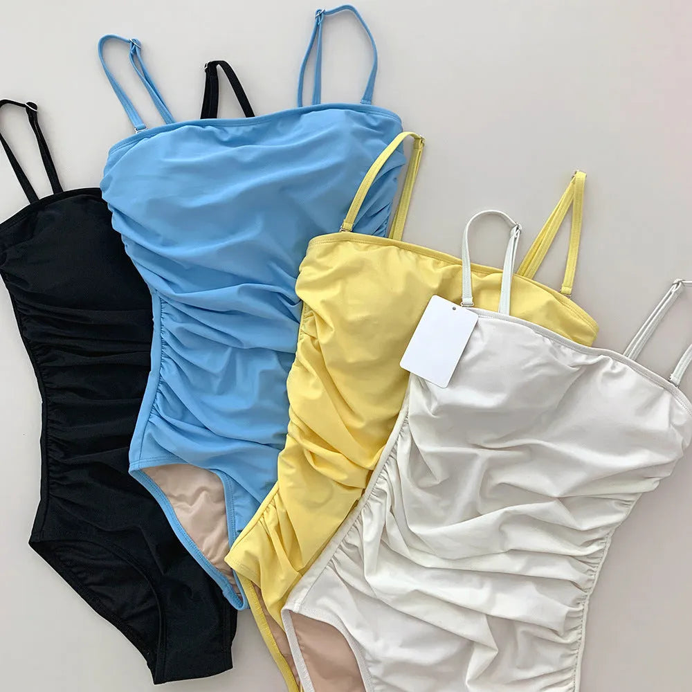 Blue sling style one-piece swimsuit with belly pleats on a mannequin