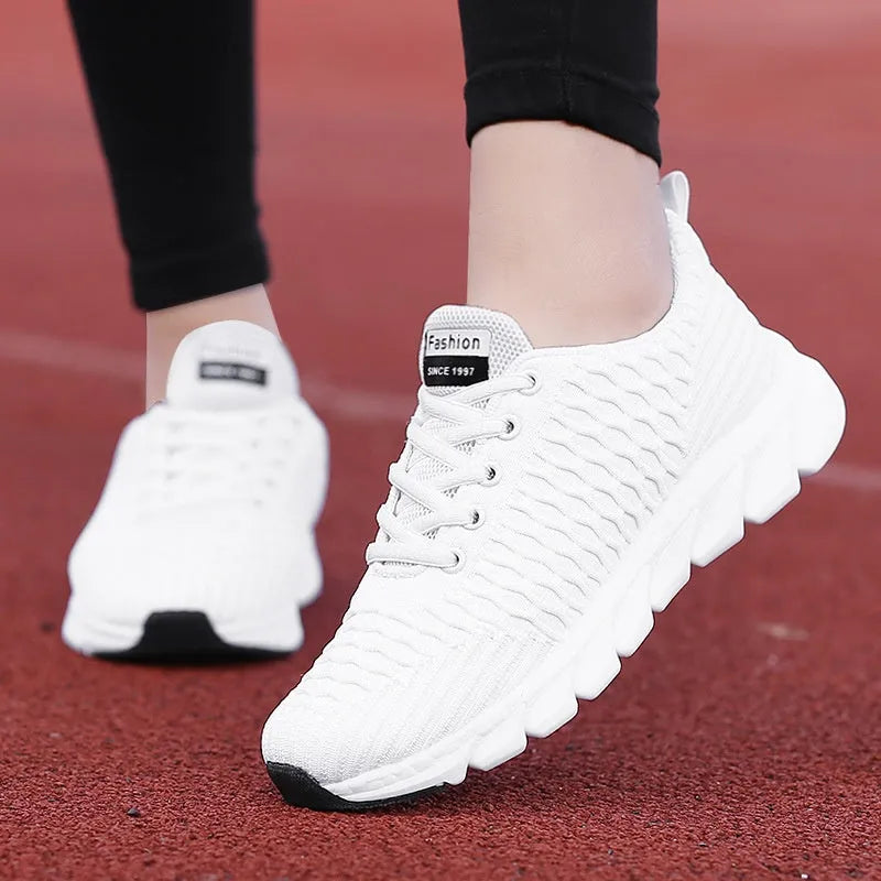 Women's running shoes with fly weave upper in black, pink, or white on a wear-resistant outsole.