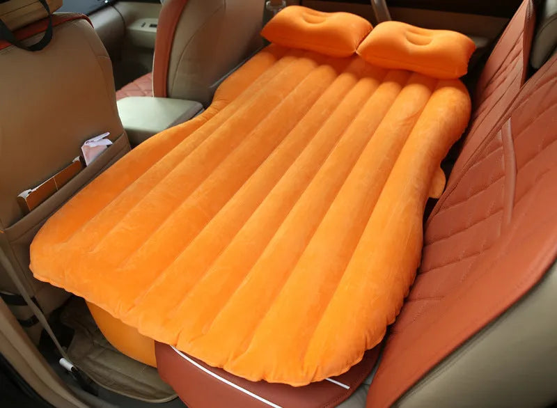 Black inflatable car bed with pillows, set up in the back of a five-seater car.