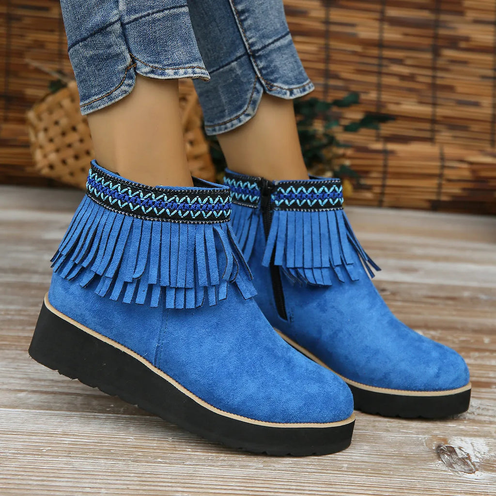 Women's dark brown suede ankle booties with a wedge heel, side zipper, and tassel detail