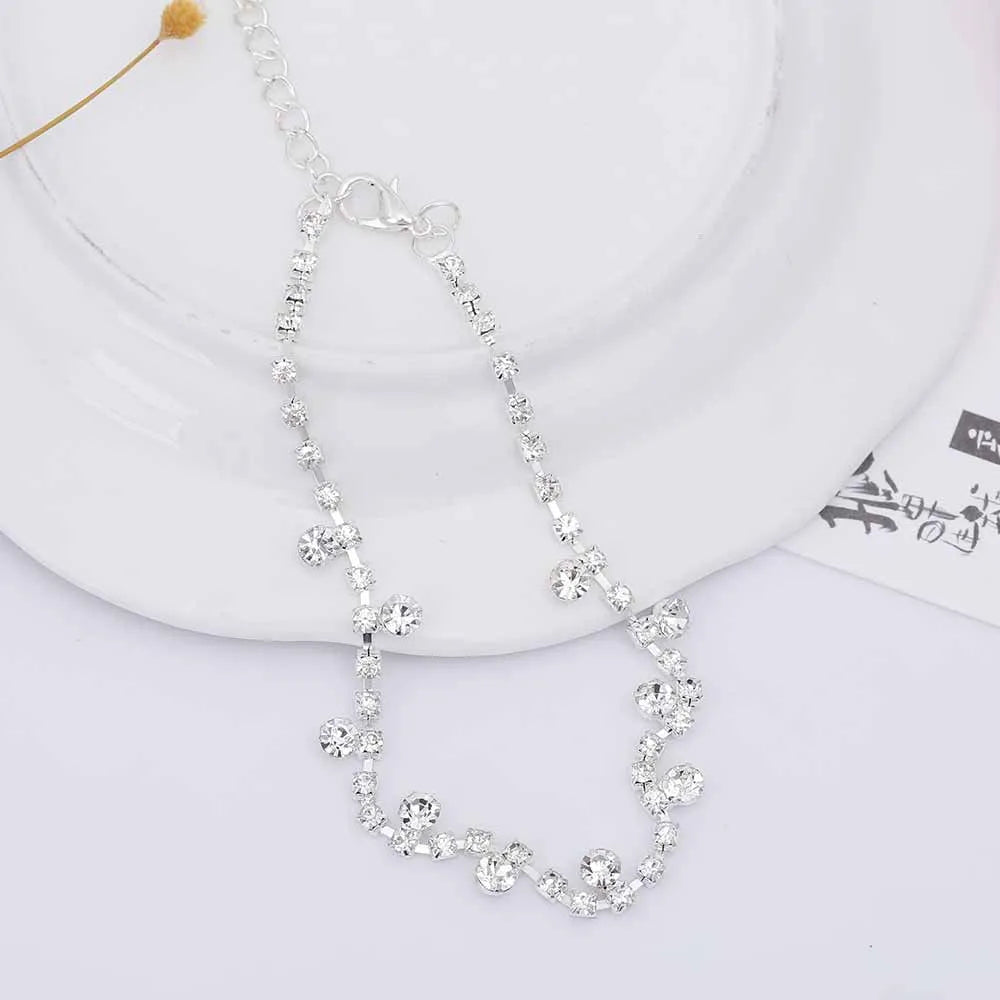 Silver alloy women's anklet with water drop tassel and stone inlay on a white background showing chain and clasp