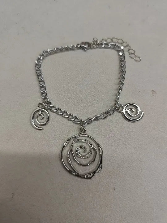 Gold spiral donut necklace, bracelet, and ear hooks set for women on a plain background.