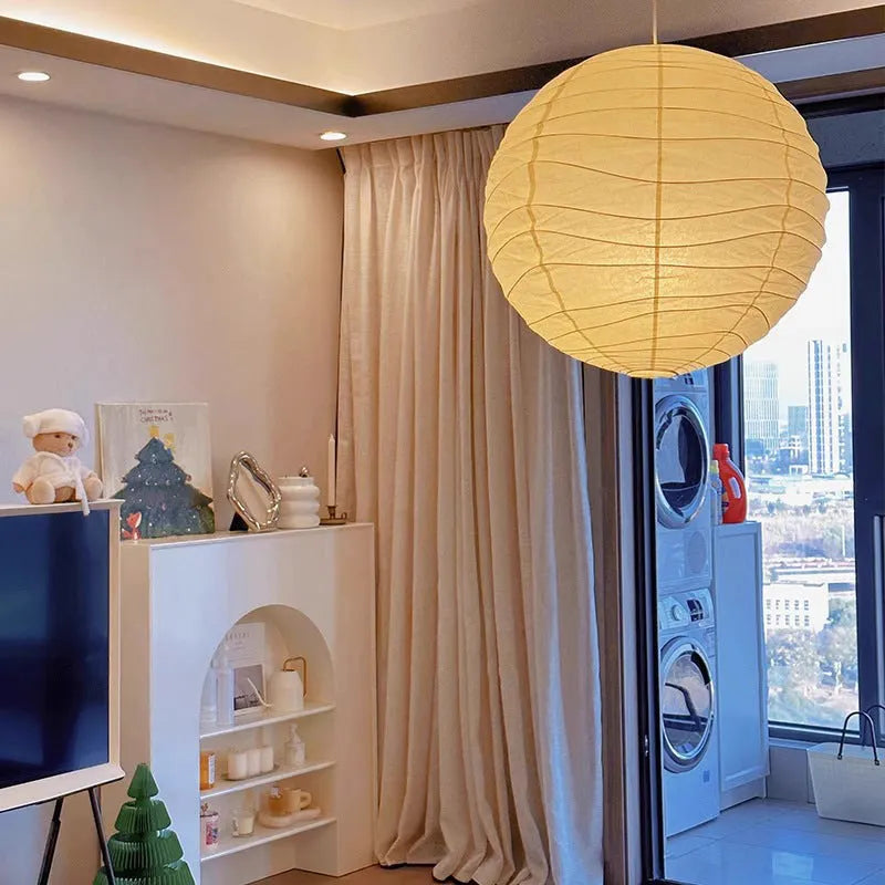 Japanese style rice paper pendant chandelier hanging from a ceiling, providing soft ambient light.