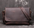 Vintage brown leather mens messenger bag with a shoulder strap, shown open to reveal internal organiser pockets.