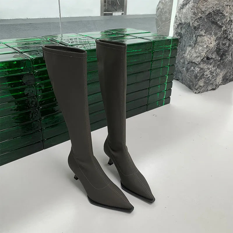 Black pointed toe stiletto heel boots with a back zipper, showing the below-the-knee shaft height.