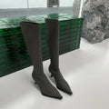 Black pointed toe stiletto heel boots with a back zipper, showing the below-the-knee shaft height.