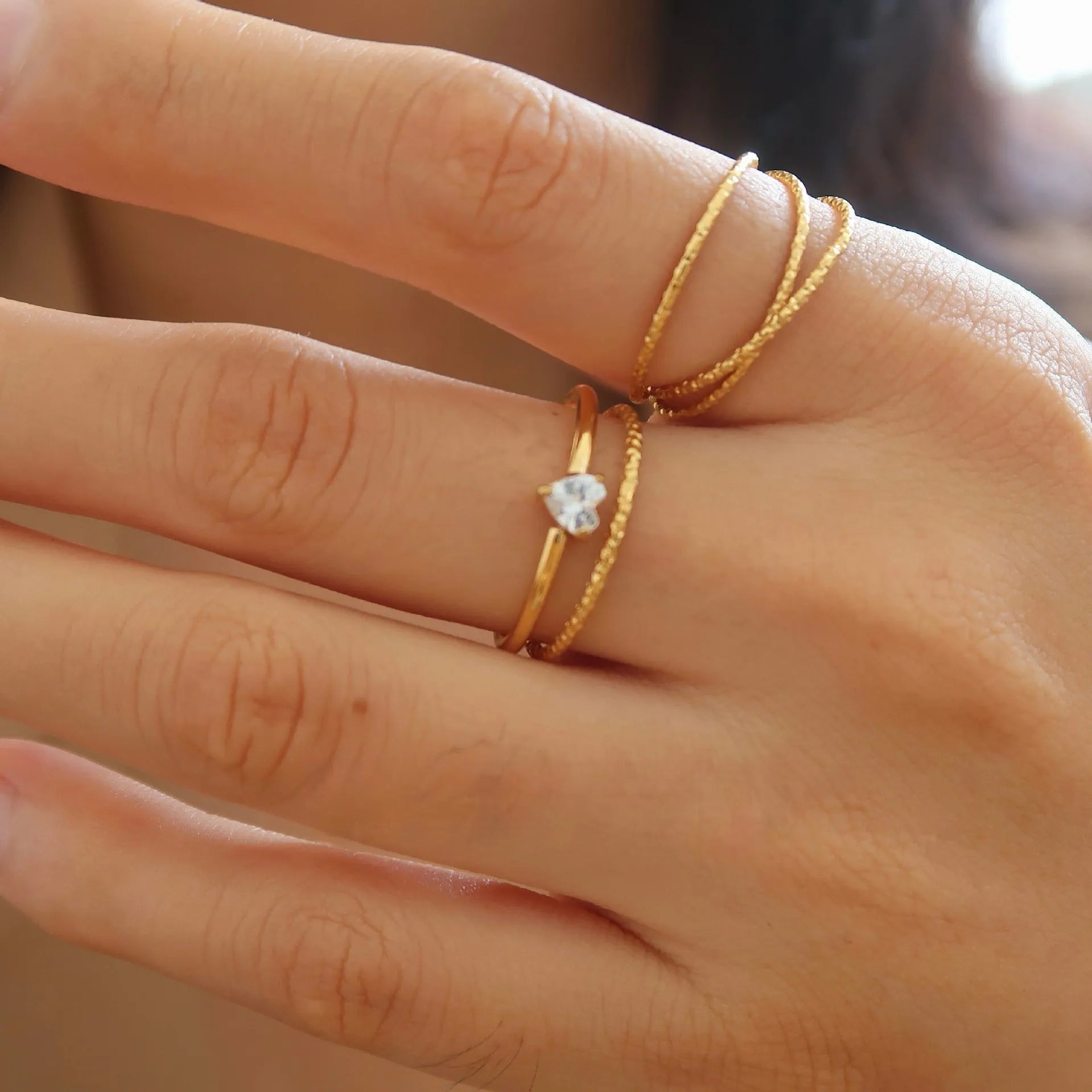 Golden heart shape stainless steel ring with electroplated finish on female hand