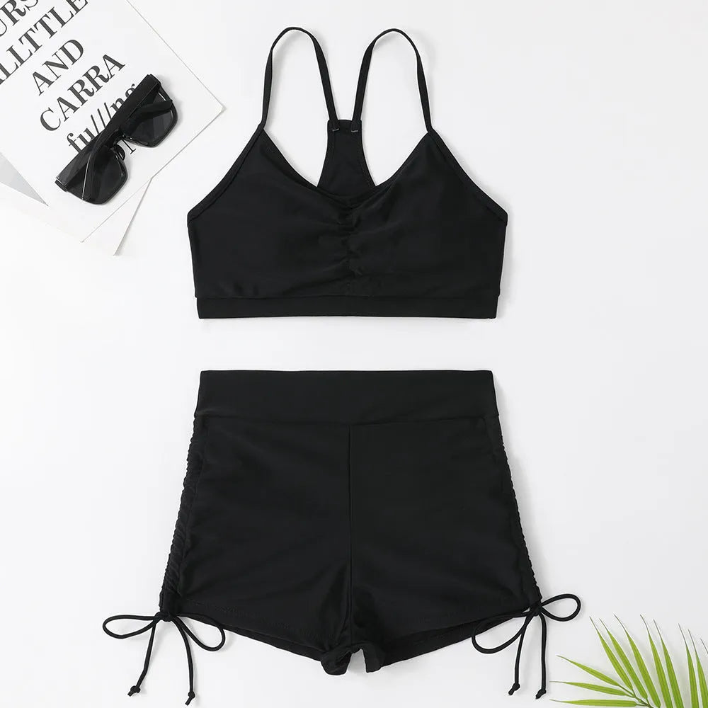 Women's high-waist split bikini swimsuit in solid black and purple colours showing two-piece design