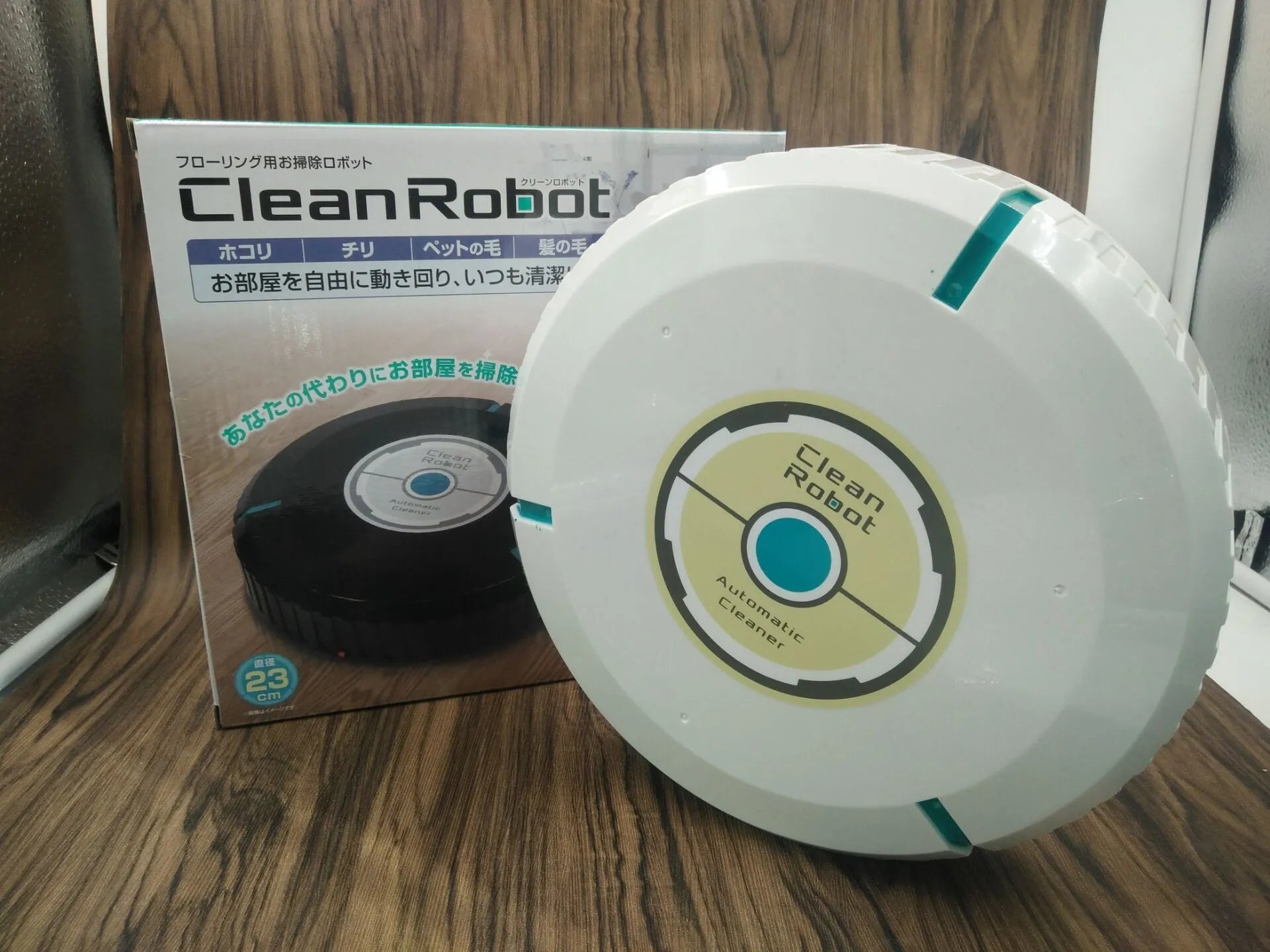 AC Sweeping Robot automatic vacuum cleaner in black or white on a wooden floor.