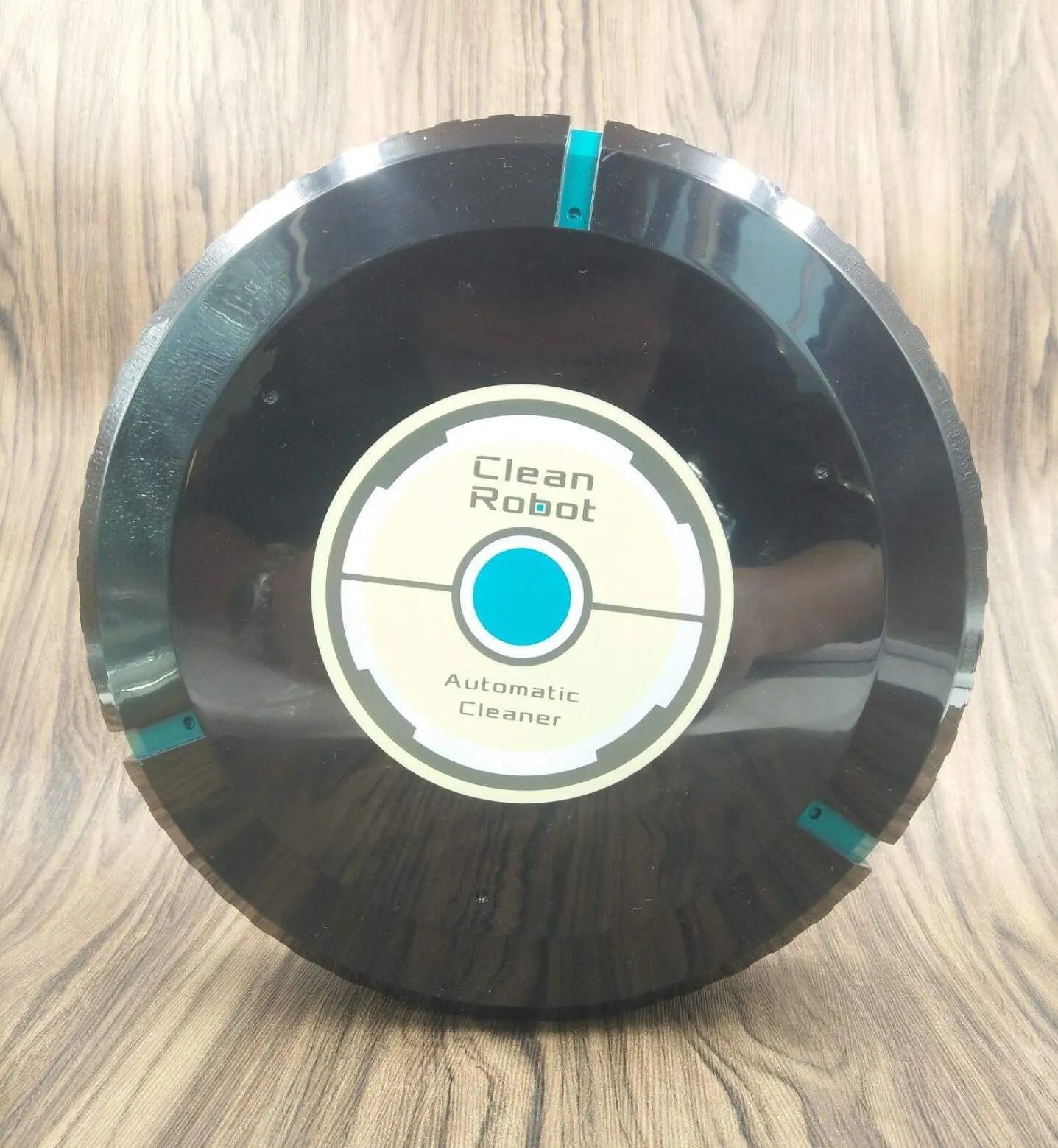AC Sweeping Robot automatic vacuum cleaner in black or white on a wooden floor.