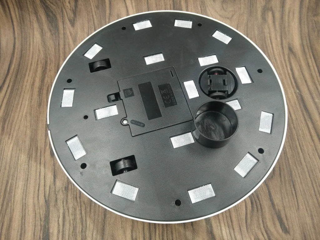 AC Sweeping Robot automatic vacuum cleaner in black or white on a wooden floor.