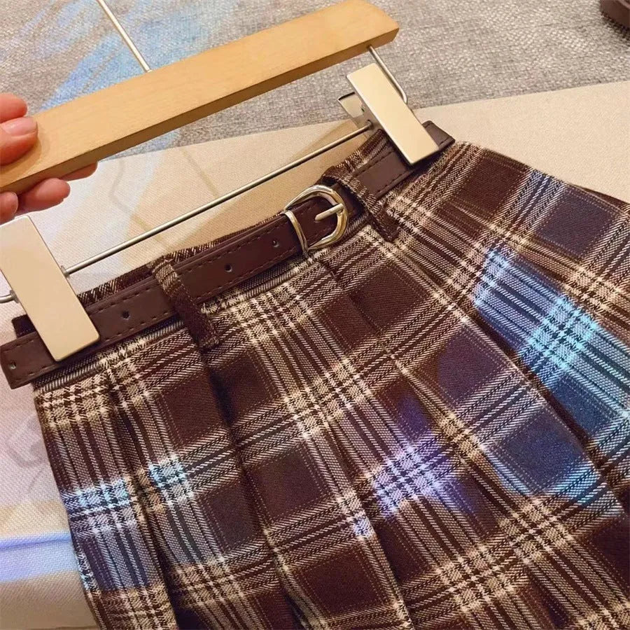 Girls plaid pleated A-line skirt in cotton blend, shown on hanger.