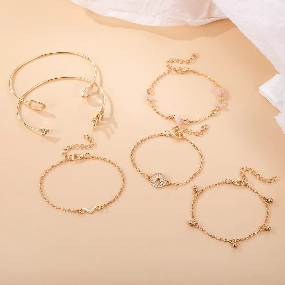 Six gold zinc alloy bracelets with V-shaped, water droplet, arrow and spot drill designs