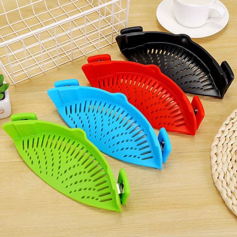 Silicone clip-on colander with stainless steel buckle attached to a pot, draining liquid, available in four colours.