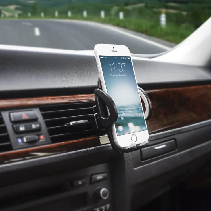 Black car air vent mobile phone holder mounted on vehicle air conditioning outlet holding smartphone