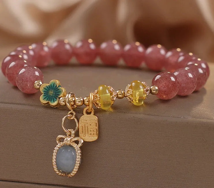 Natural strawberry quartz beaded bracelet red alloy with rhinestone details on white background