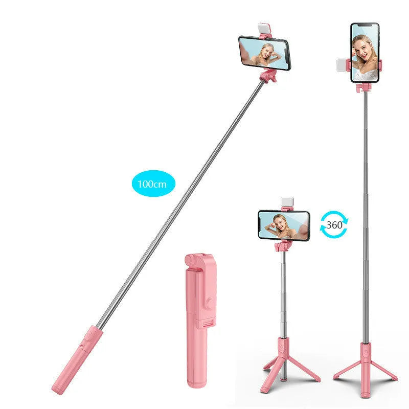 Black Bluetooth selfie stick with extended tripod legs and a fill light, holding an iPhone.