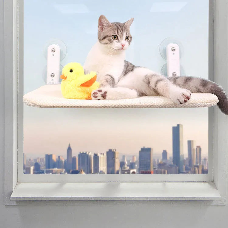 Foldable grey mesh cat hammock with suction cups mounted on a window