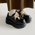 Women's matte black chunky heel lace-up shoes with a round toe and thick rubber sole.