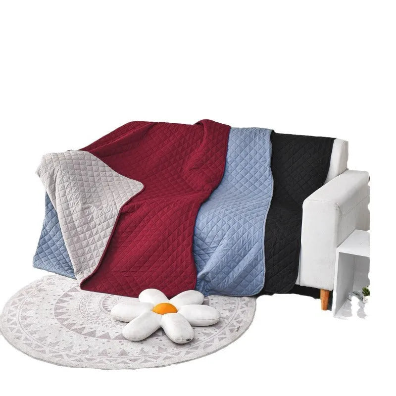 Soft reversible dog blanket couch cover in burgundy with grey reverse side, laid flat on sofa