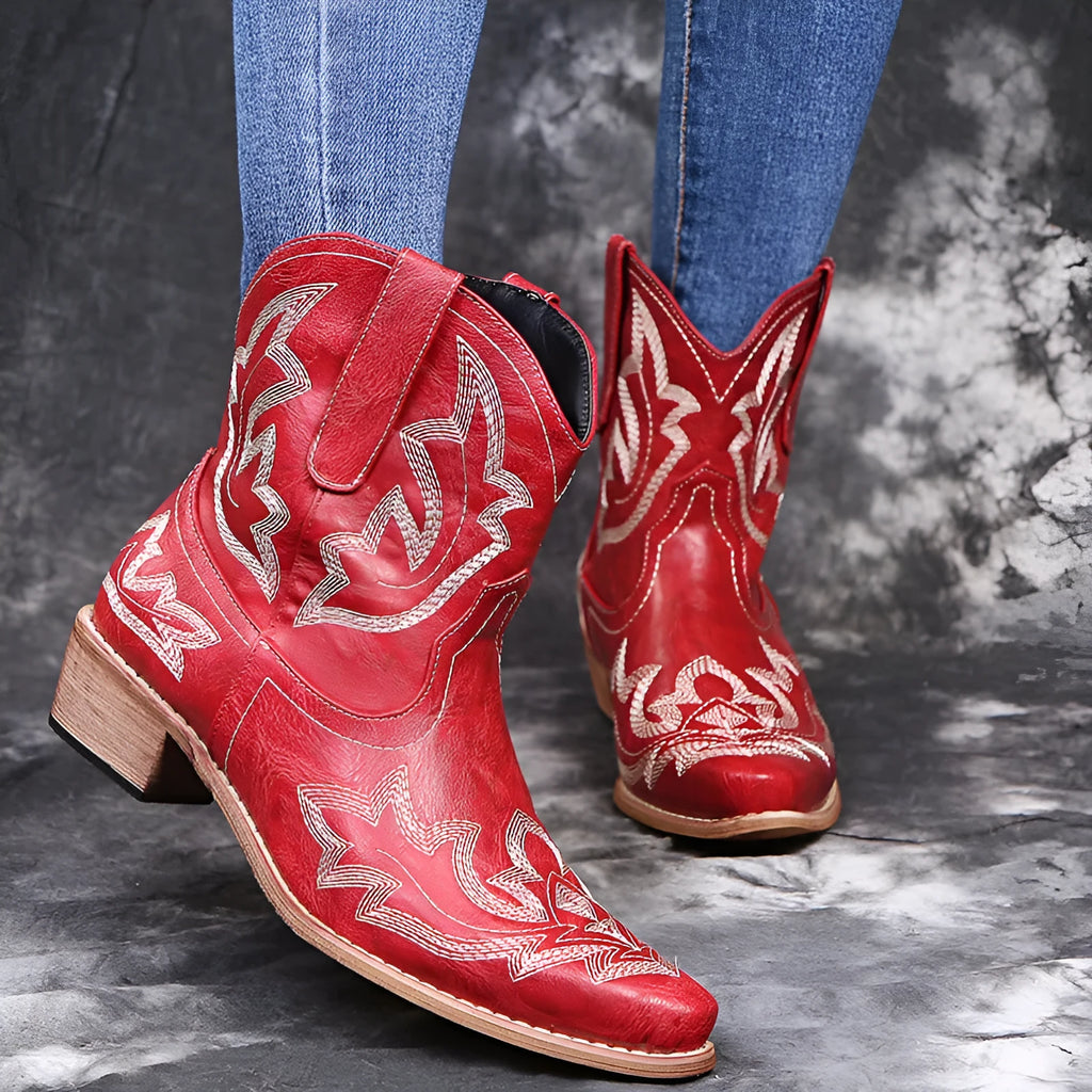 Women's blue embroidered cowboy ankle boots with a low wedge heel and pointed toe.