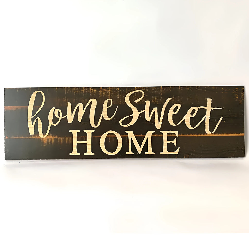 Wooden carved Home Sweet Home wall hanging ornament in black, 40cm long, 12cm high, on a white wall