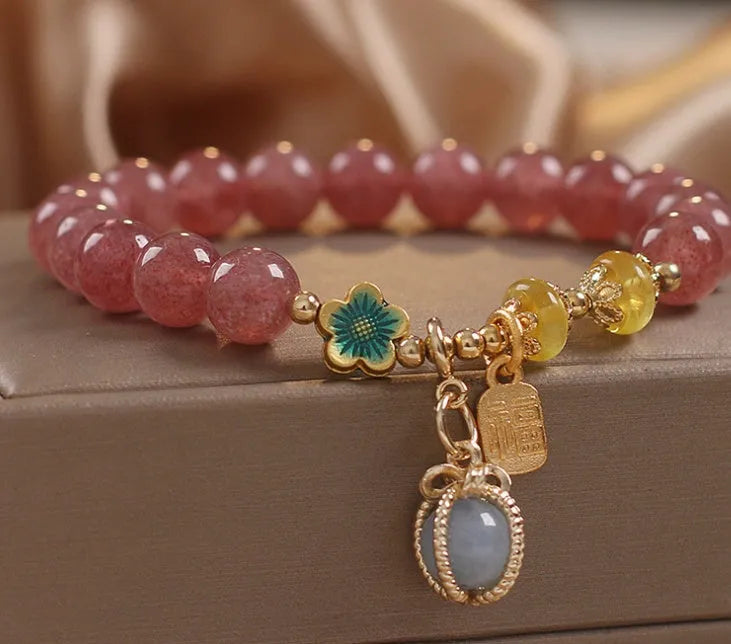 Natural strawberry quartz beaded bracelet red alloy with rhinestone details on white background