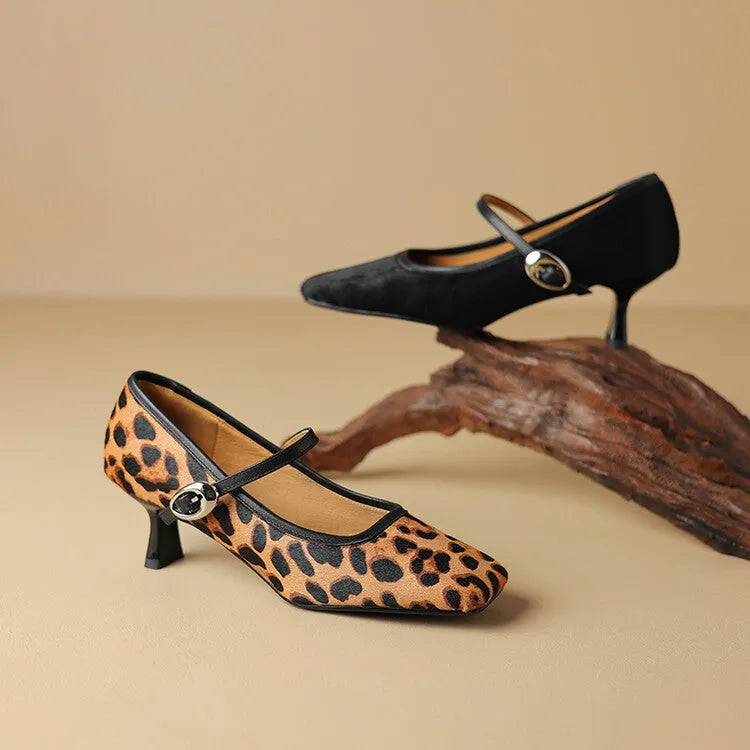 Women's black square toe stiletto ankle-strap heels with horse hair upper on a plain background.