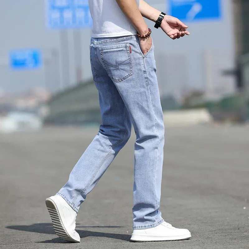 Men's smoky grey low waist straight leg jeans with a zipper fly, shown on a hanger.