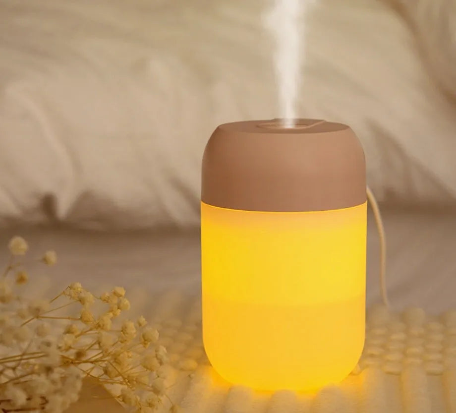 White cylindrical USB-powered mini humidifier on a desktop.
