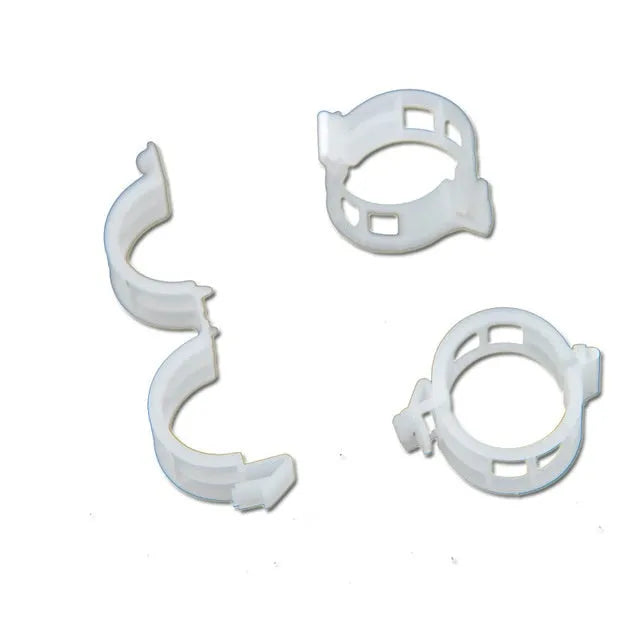 Assorted coloured plastic plant training clips for securing tomato plant branches in the garden.