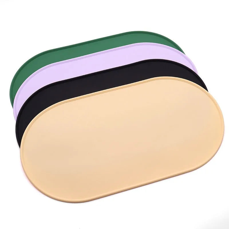 Green silicone waterproof placemat for cat bowls on a wooden floor.