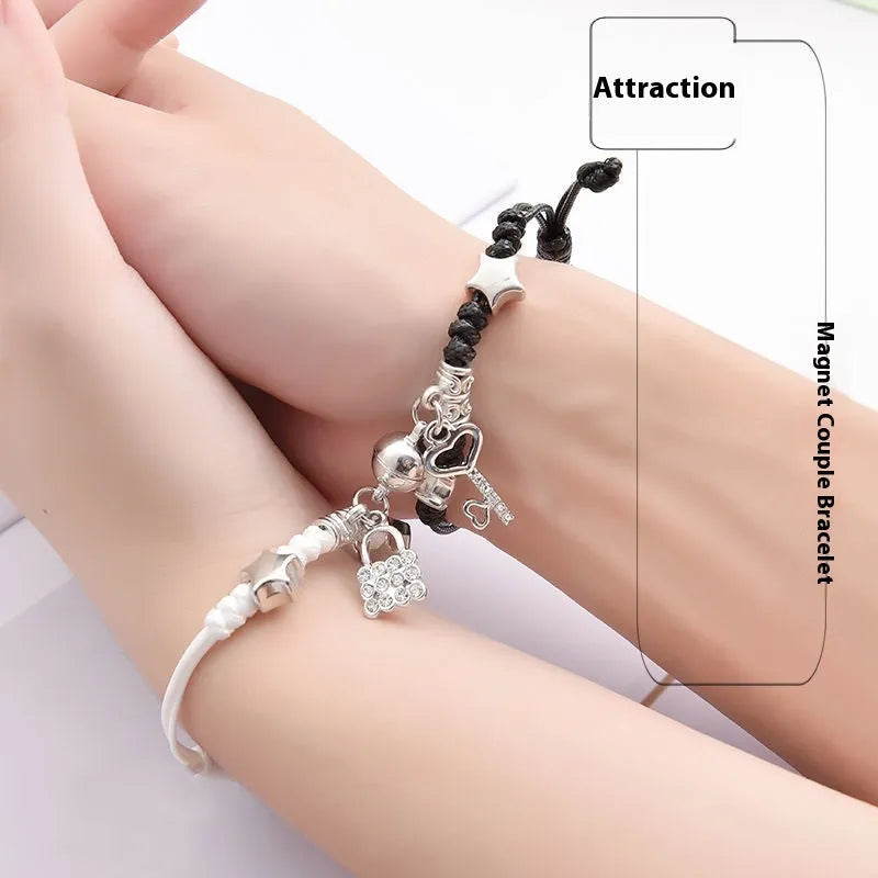 A pair of silver alloy bracelets with magnetic clasps and assorted charm designs including crowns, stars, and clovers.