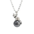 Close-up of a sterling silver cat pendant on a delicate clavicle chain necklace.