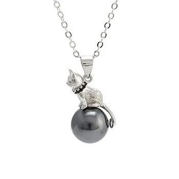 Close-up of a sterling silver cat pendant on a delicate clavicle chain necklace.