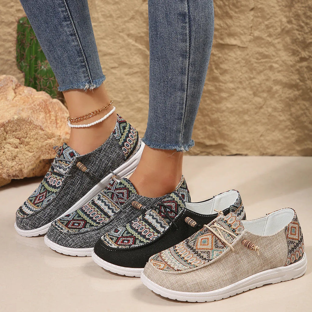 Women's black flat shoes with round toe and slip-on design on neutral background