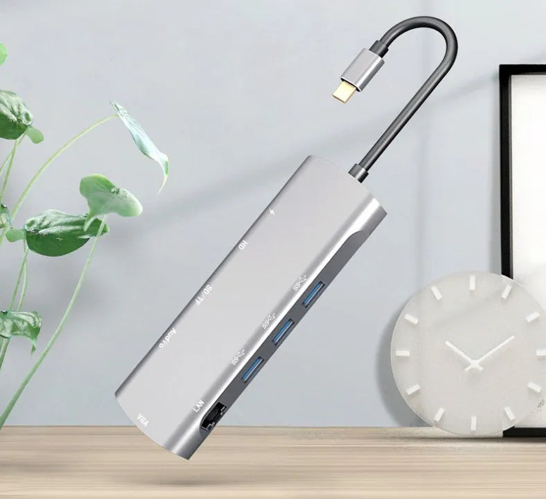 Grey aluminium alloy USB-C docking station with HDMI, VGA, and USB 3.0 ports and integrated 140mm cable
