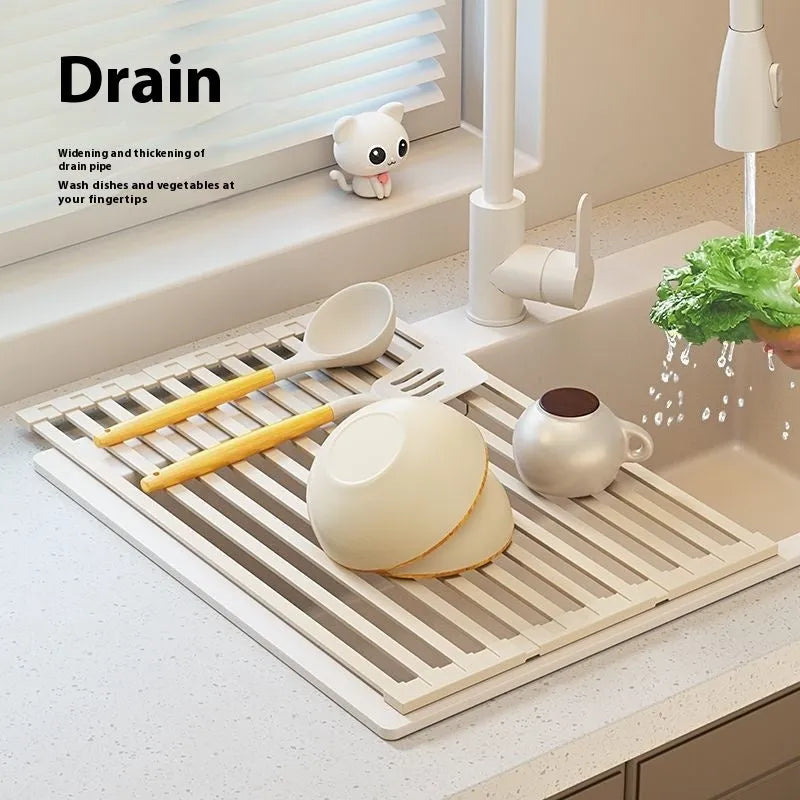 Foldable milky white stainless steel kitchen draining rack next to a sink.