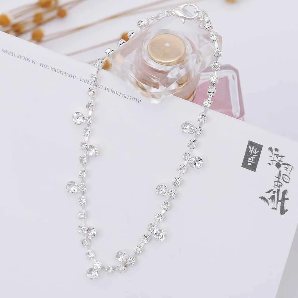 Silver alloy women's anklet with water drop tassel and stone inlay on a white background showing chain and clasp
