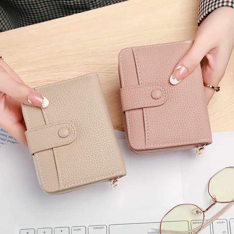 A beige ladies' short wallet with a textured lychee pattern, shown folded closed.