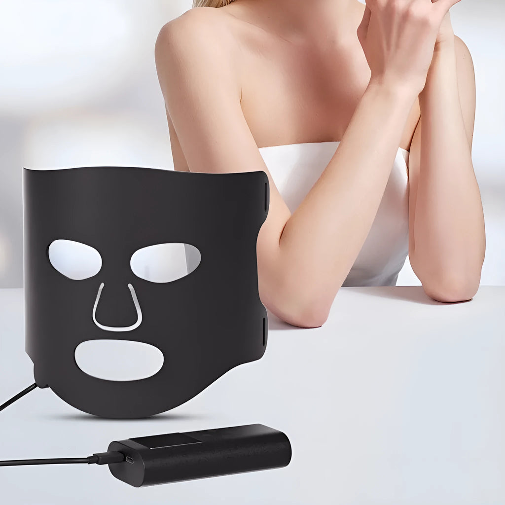 Black and white LED phototherapy face mask with controller, showing seven coloured light modes for skin treatment.