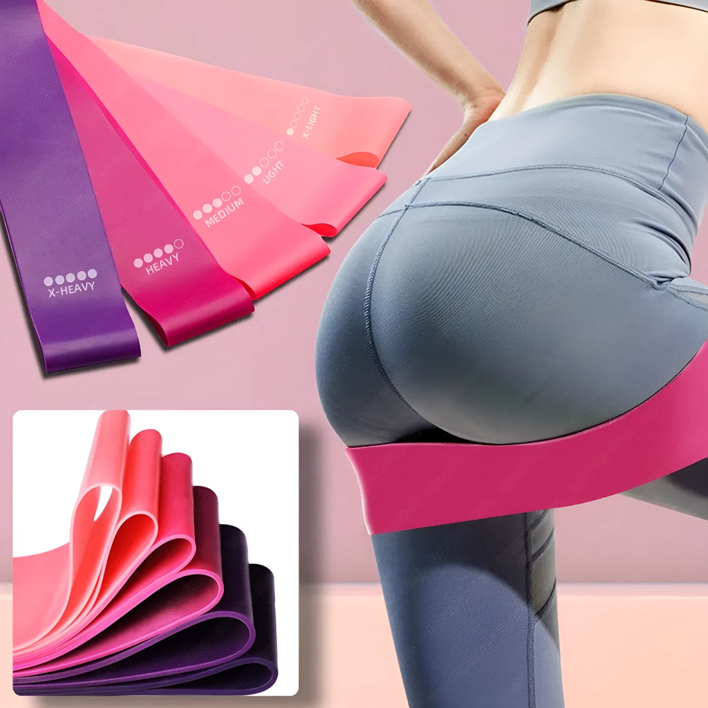 Four colour-coded resistance bands in purple, pink, blue, and grey with non-slip inner lines laid flat on a surface